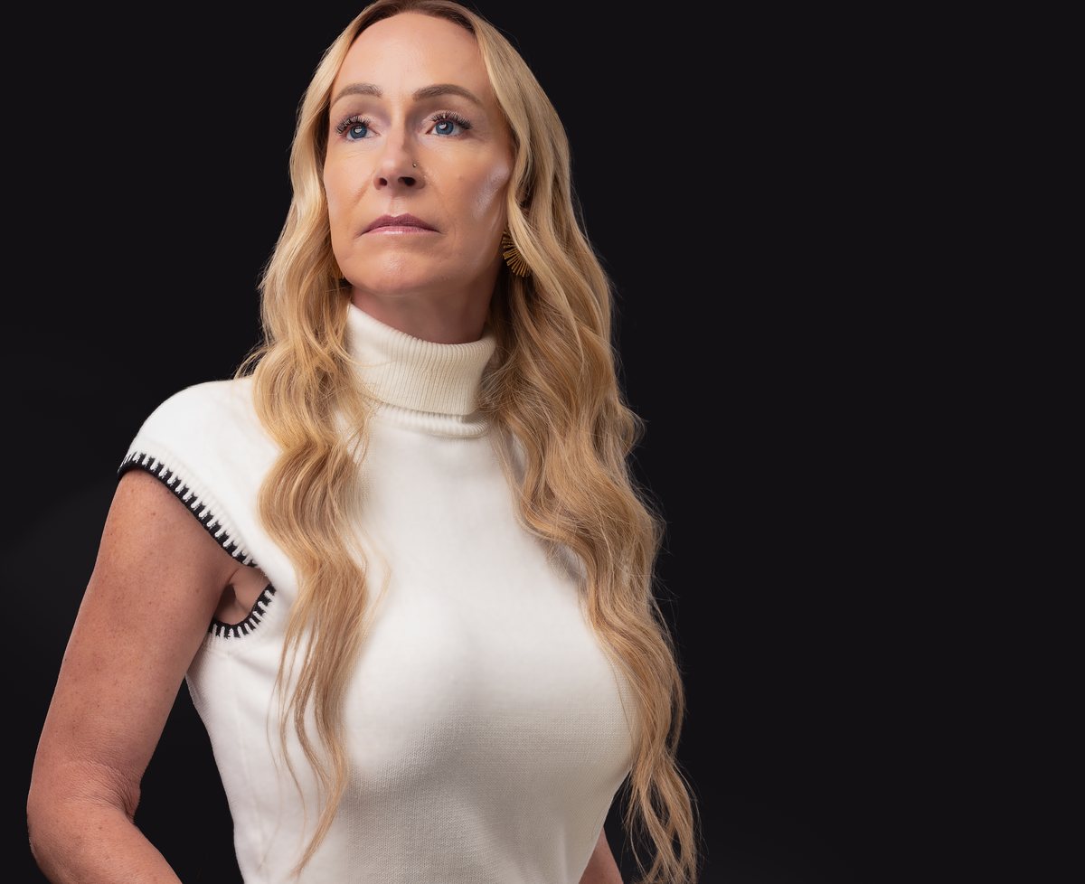 Stacey Melton in a white sleeveless top, looking to one side