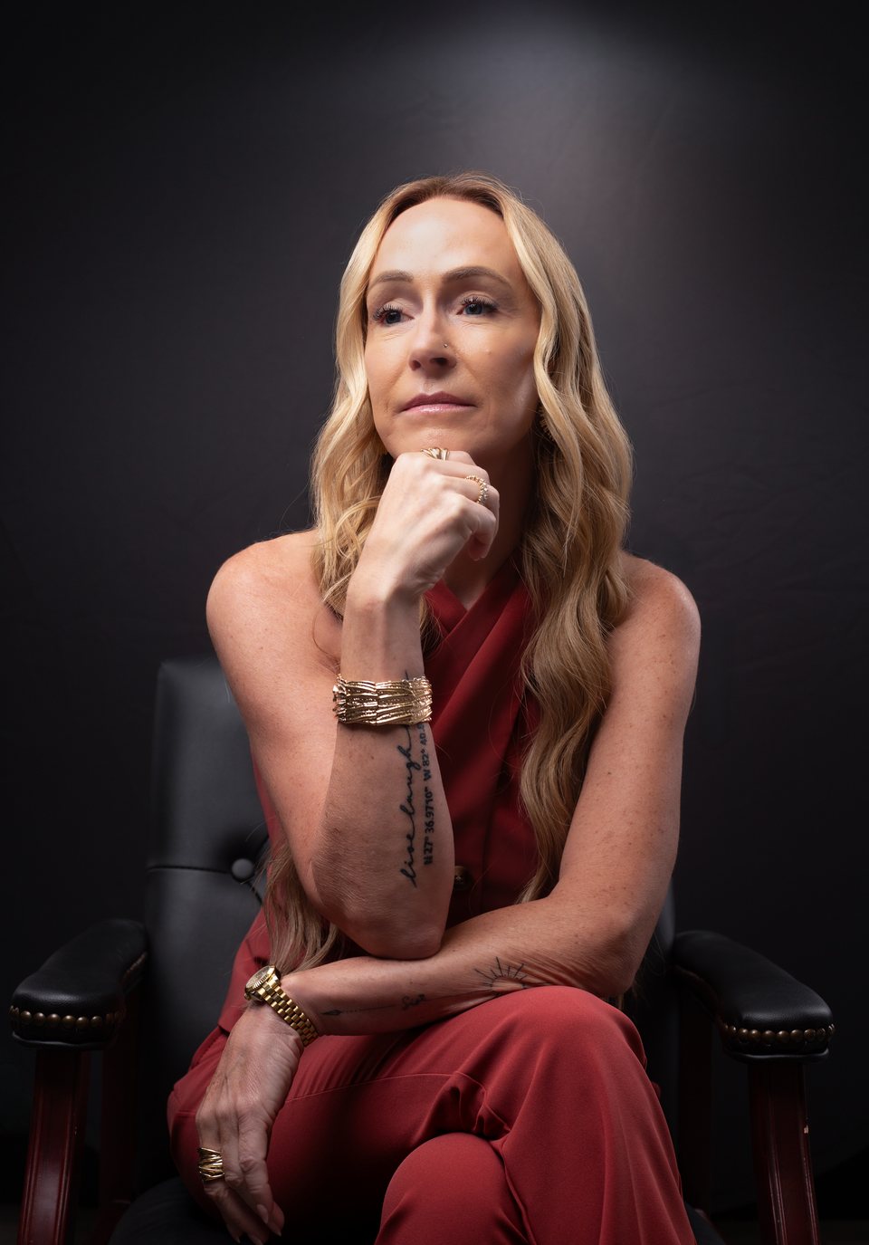 Stacey Melton, mortgage broker in Phoenix and Tampa Bay, seated in a leather chair in a red outfit
