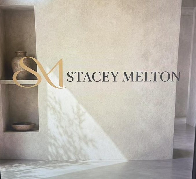 The Stacey Melton logo on a plaster wall